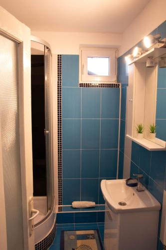 a blue bathroom with a sink and a toilet at TheRefuge in Curtea de Argeş
