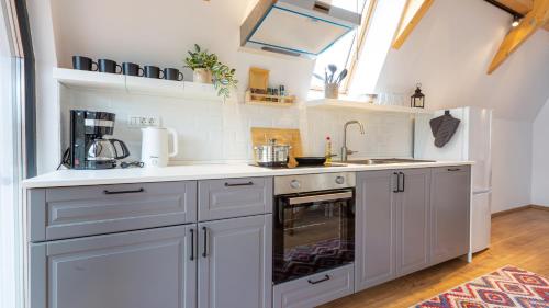 a kitchen with white cabinets and an oven at Relax Cabins in Cristian