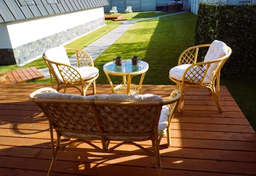 three chairs and a table on a deck at Relax Cabins in Cristian