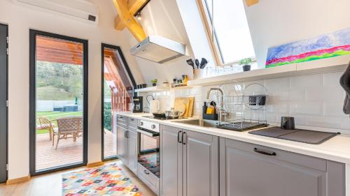 a kitchen with white cabinets and a large window at Relax Cabins in Cristian