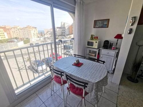 d'une table et de chaises dans une cuisine avec balcon. dans l'établissement 021 Roches Rouges A22, au Cap d'Agde