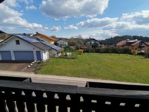 a view of a yard with houses and a fence at Ferienwohnung am Sonnenberg in Hammelbach