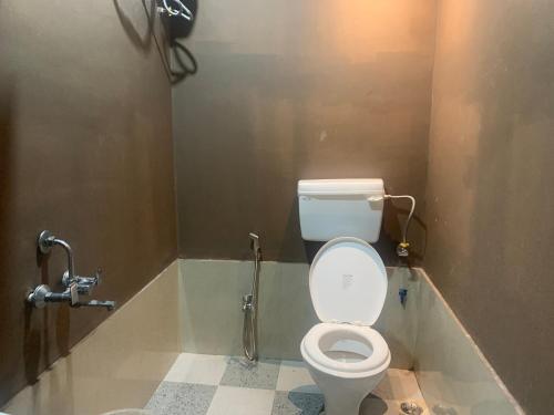 a bathroom with a white toilet in a stall at Brookside B&B in Dibrugarh