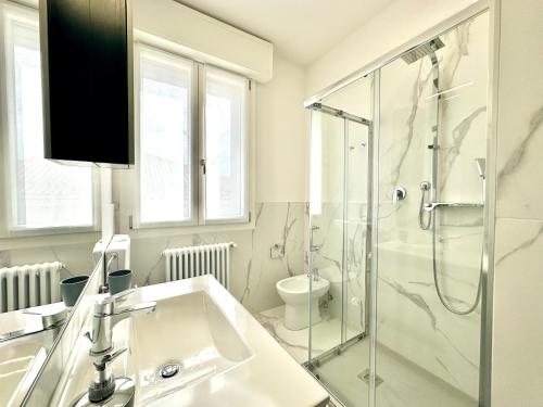 a bathroom with a sink and a glass shower at Donnino Apartments in Fidenza