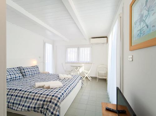 um quarto branco com uma cama e uma mesa em Attico a Marina Centro em Rimini