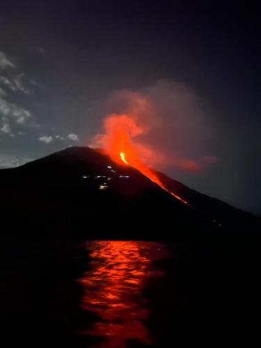 a mountain with a fire on top of it at night at Hotel Ossidiana Stromboli Center in Stromboli