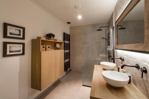 a bathroom with two sinks and a shower at Vakantiewoning 'De Teut' in Zonhoven