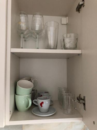 a cupboard filled with glasses and plates and bowls at Adrian Home Delice in Ploieşti