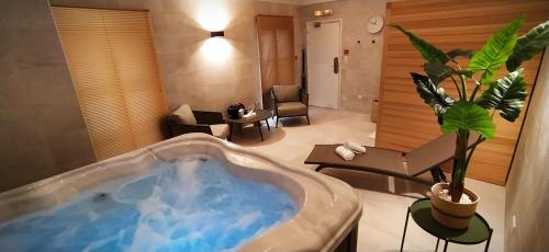 a large bath tub in a living room at Hôtel Les Nations The Originals Boutique VICHY in Vichy