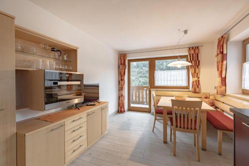 a kitchen with a table and a dining room at Apartments Soval in Santa Cristina in Val Gardena