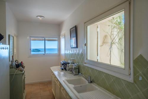 une salle de bain avec un lavabo et une fenêtre dans l'établissement Villa Uptica 16 pers piscine vue mer, à Porto-Vecchio