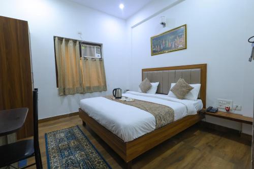 een slaapkamer met een bed, een bureau en een raam bij Taj Classic Agra in Agra