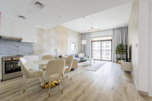 a kitchen and living room with a table and chairs at Nasma Luxury Stays - Fabulous Apartment With Balcony Near MJL's Souk in Dubai