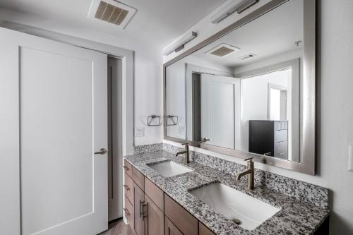 a bathroom with two sinks and a large mirror at Downtown 1br w deck gym nr Congress Ave ATX-208 in Austin