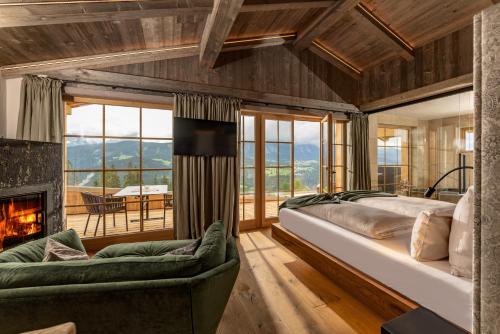 a bedroom with a large bed and a fireplace at Almwelt Austria in Schladming
