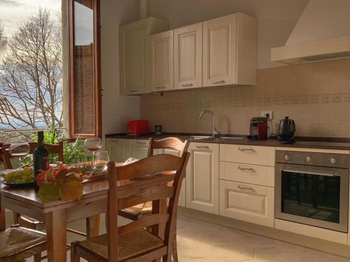 una cocina con armarios blancos y una mesa con sillas. en House with a view in Tuscany, en San Gusmè