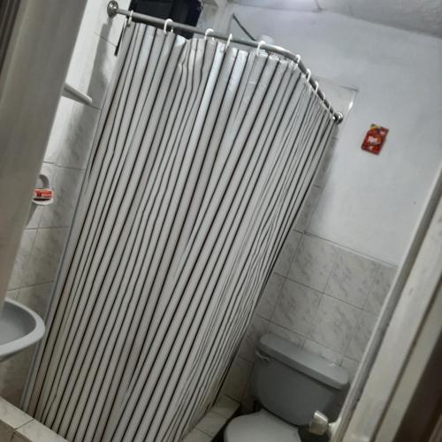 ein Badezimmer mit einem Heizkörper neben einem WC in der Unterkunft Maya Suite in Cuenca