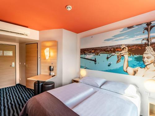 コンスタンツにあるB&B Hotel Konstanzのベッドルーム1室(ベッド1台付)が備わります。壁には大きな絵画が飾られています。