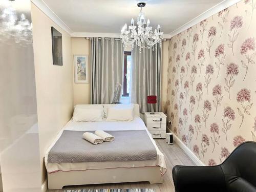 1 dormitorio con cama y lámpara de araña en Cosy 2 bedroom Detached House in Central London en Londres