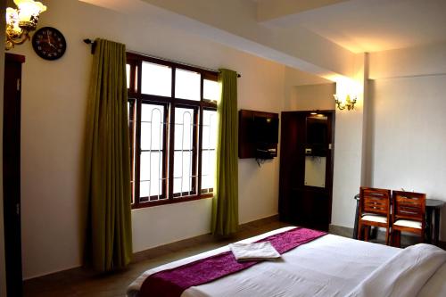 1 dormitorio con cama y ventana grande en LILY GUEST HOUSE en Shillong