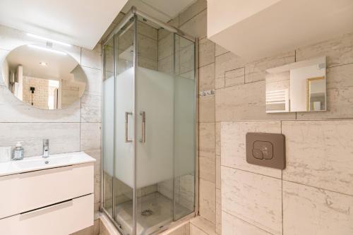 une salle de bain avec une douche en verre et un lavabo dans l'établissement MBA Splendide Appart - Réaumur - Paris Centre, à Paris