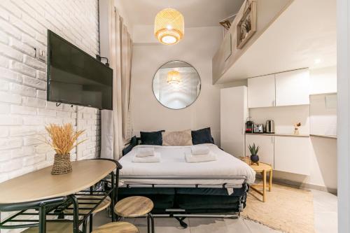 une chambre avec un lit, une table et une télévision dans l'établissement MBA Splendide Appart - Réaumur - Paris Centre, à Paris
