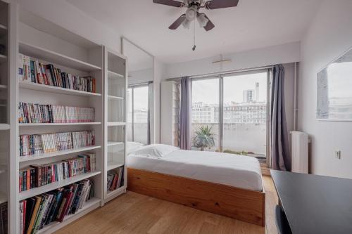 a bedroom with a bed and book shelves with books at Veeve - Home Comforts by the Eiffel Tower in Paris