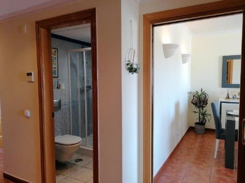 un couloir avec des toilettes et une salle de bains avec un lavabo dans l'établissement Eden Jasmim by FHR, à Quarteira