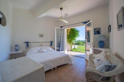 une chambre avec un lit et une porte coulissante en verre dans l'établissement Villa Uptica 16 pers piscine vue mer, à Porto-Vecchio