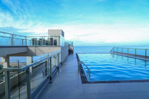 a swimming pool on the top of a building with the ocean at Ocean Breeze Studio Apartment Negombo in Negombo