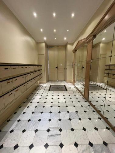 La salle de bains est pourvue de carrelage noir et blanc. dans l'établissement Michelangelo Résidence, à Nice