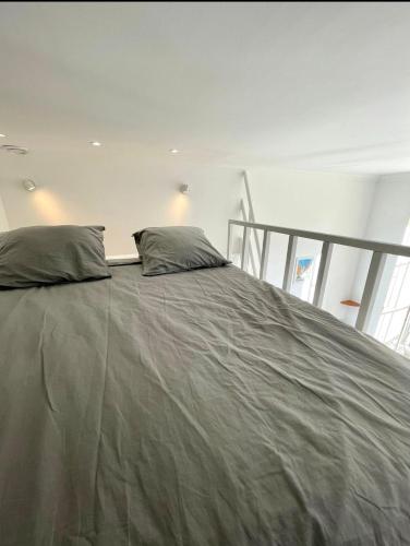 un grand lit avec deux oreillers dessus dans l'établissement Michelangelo Résidence, à Nice