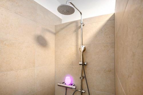 a shower with a pink light in a bathroom at Goldberg in Grünstadt