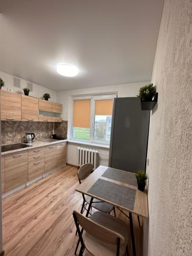 cocina con mesa y sillas en una habitación en Jaukus butukas en Kėdainiai
