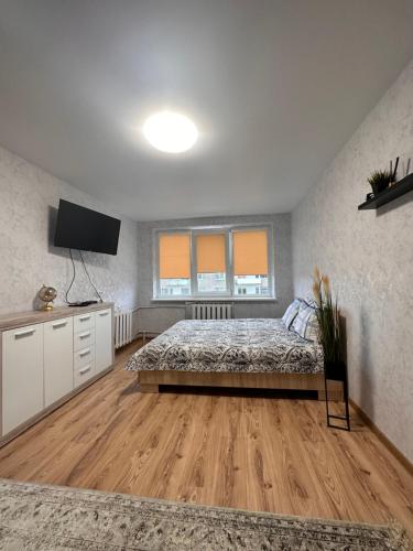a bedroom with a bed and a flat screen tv at Jaukus butukas in Kėdainiai