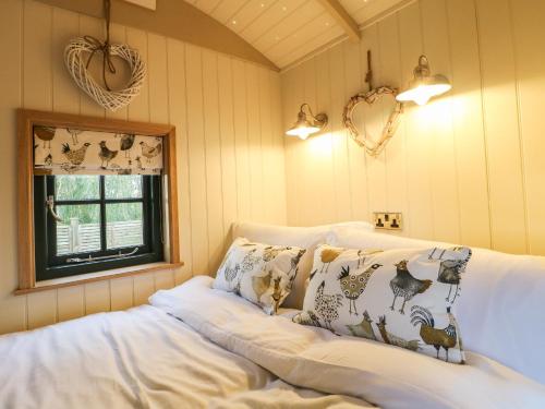 a room with a couch with pillows and a window at Poppie's Shepherds Hut in Nottingham