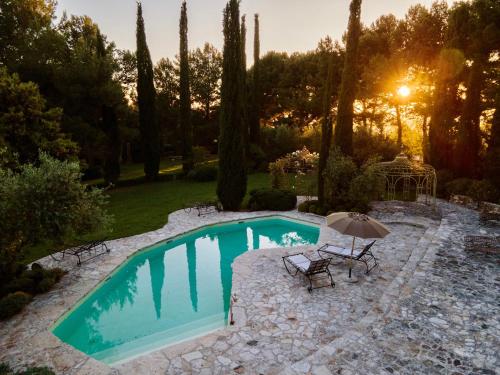 a swimming pool with a table and an umbrella at Boutique Hotel Poggio ai Santi - Adults Only in San Vincenzo