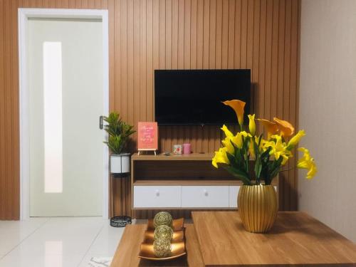 a living room with a vase with yellow flowers on a table at Brenthill Condominium in Baguio