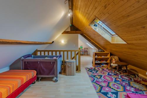 un dormitorio en el ático con una cama y una escalera en Gîte de charme, idéal pour 4, en Saint-Jory-de-Chaleix