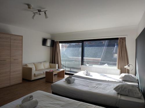 a bedroom with two beds and a large window at Room in Studio - Value Stay Residence Mechelen - Studio Triple in Mechelen