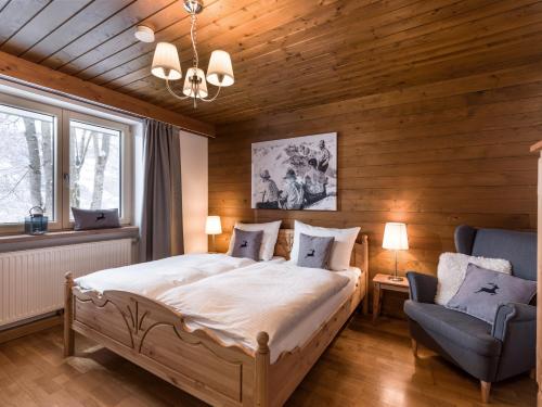 sypialnia z dużym łóżkiem i krzesłem w obiekcie Chalet Achenberg w mieście Brixen im Thale
