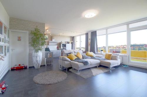 霍蓋思的住宿－Penthouse 383，客厅配有白色沙发和黄色枕头。
