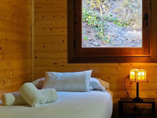 um quarto com uma cama branca e uma janela em Can Jorge em Camprodon
