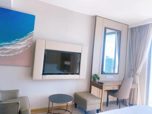 a hotel room with a desk and a tv at Panorama in Nha Trang