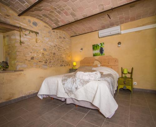 1 dormitorio con 1 cama en una pared de ladrillo en Gîte avec jacuzzi privatif dans un mas provençal, en Les Fumades-Les Bains