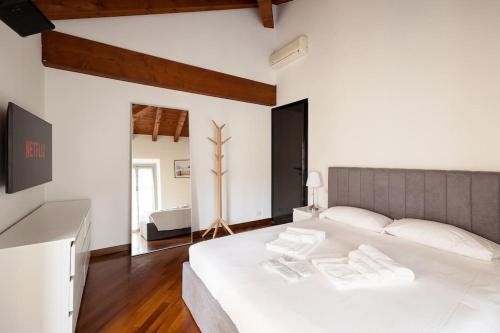 a bedroom with a large white bed with white pillows at Luxury apartment + private parking - Como center in Como