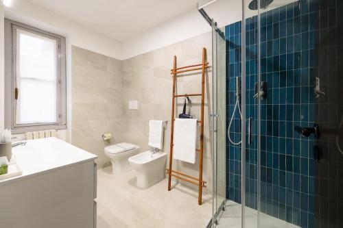 a bathroom with a toilet and a glass shower at Luxury apartment + private parking - Como center in Como