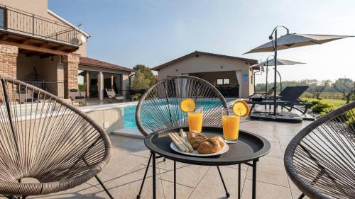 普拉的住宿－Wonderful Villa Mattuzzi with private pool near the town，一张桌子,上面有盘子食物和两把椅子