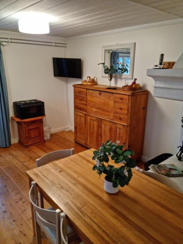 a dining room with a wooden table and a dresser at Midgård in Jörn