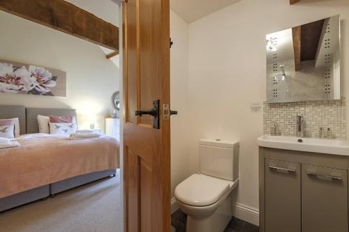 uma casa de banho com uma cama, um WC e um lavatório. em Kings Beck Barn em Norwich